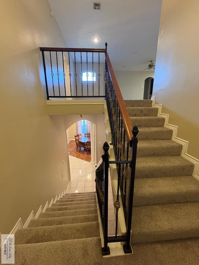 901 Plantation St, Brownsville, TX 78526 - stairway featuring carpet, arched walkways, and a ceiling fan
