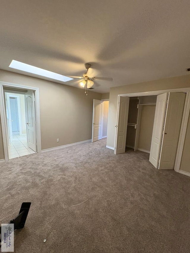 901 Plantation St, Brownsville, TX 78526 - unfurnished bedroom featuring light carpet, a skylight, baseboards, a ceiling fan, and a closet