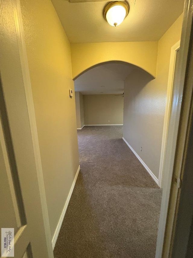 901 Plantation St, Brownsville, TX 78526 - hall featuring arched walkways, dark colored carpet, and baseboards