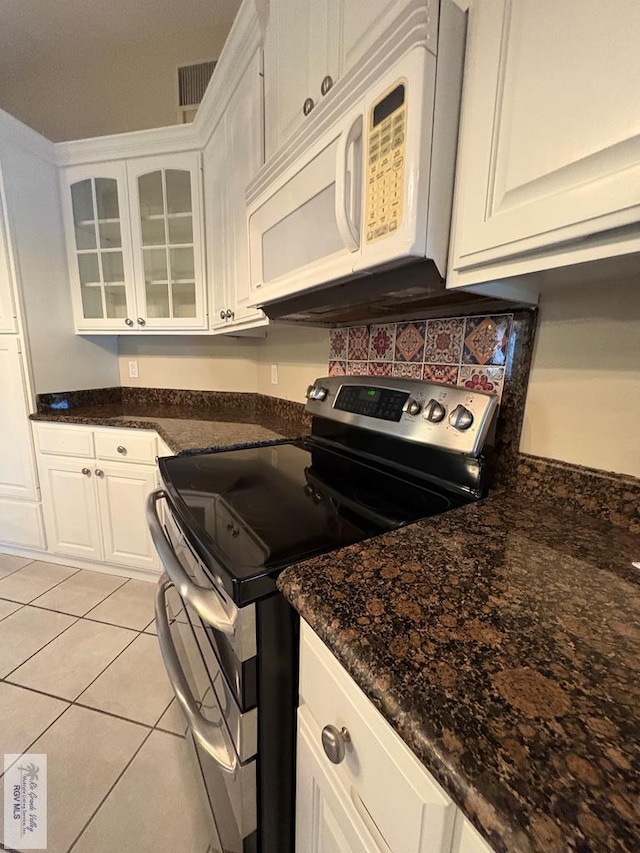 901 Plantation St, Brownsville, TX 78526 - kitchen with electric range, white microwave, glass insert cabinets, and white cabinetry