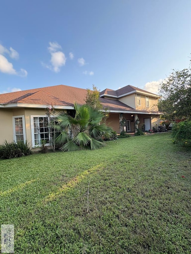 901 Plantation St, Brownsville, TX 78526 - rear view of house with a lawn and stucco siding