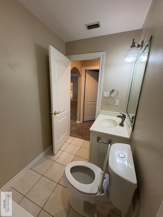 901 Plantation St, Brownsville, TX 78526 - half bathroom with toilet, tile patterned flooring, vanity, and baseboards