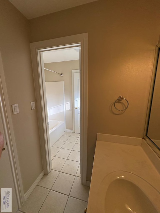 901 Plantation St, Brownsville, TX 78526 - bathroom with tile patterned flooring, vanity, a bathtub, and baseboards