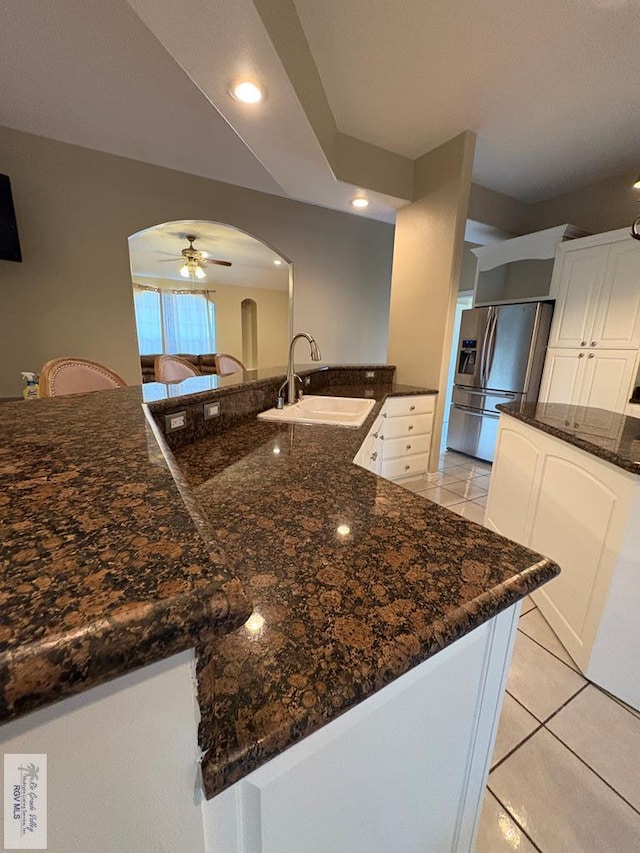 901 Plantation St, Brownsville, TX 78526 - kitchen with a sink, arched walkways, stainless steel fridge with ice dispenser, a ceiling fan, and white cabinetry