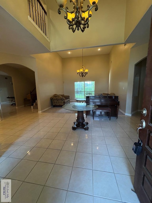 901 Plantation St, Brownsville, TX 78526 - entryway with a towering ceiling, a chandelier, arched walkways, light tile patterned floors, and baseboards