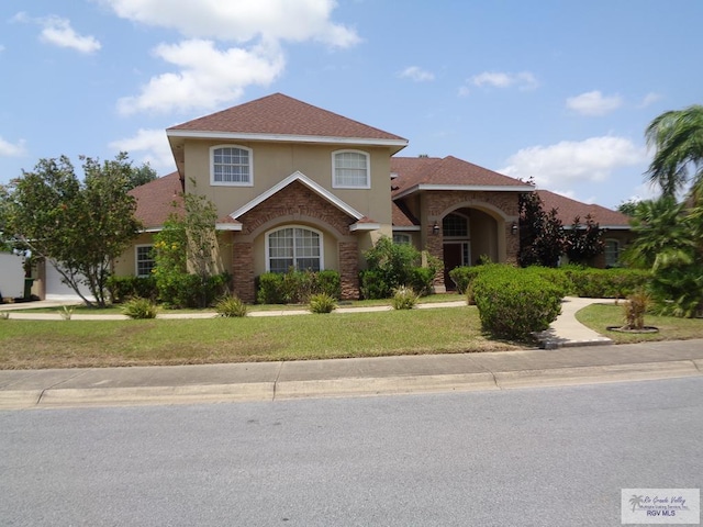 901 Plantation St, Brownsville, TX 78526 - traditional-style home with a front yard, stucco siding, and stone siding