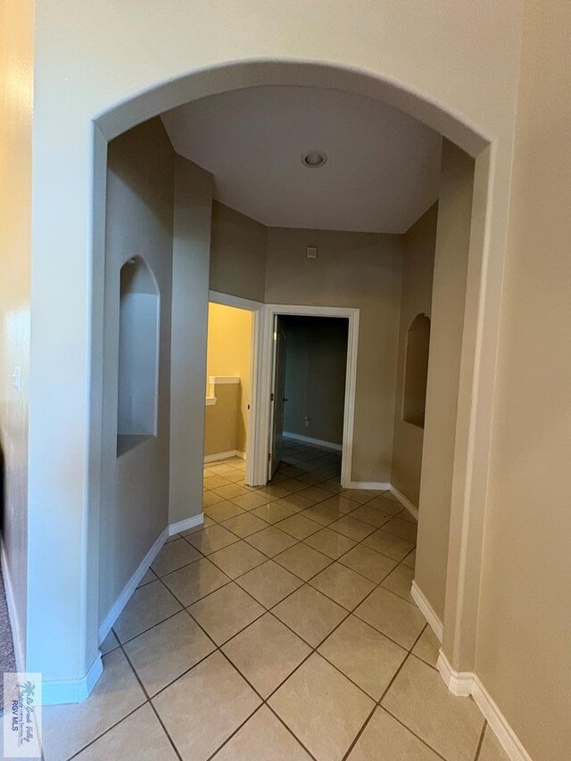 901 Plantation St, Brownsville, TX 78526 - corridor with arched walkways, light tile patterned flooring, and baseboards