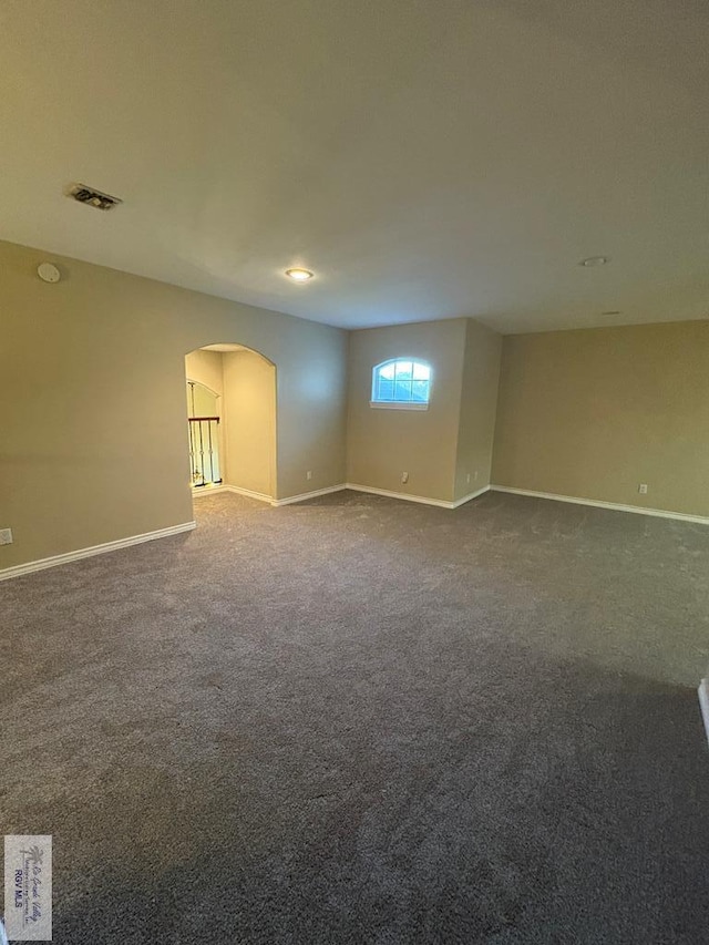 901 Plantation St, Brownsville, TX 78526 - empty room featuring arched walkways, dark carpet, and baseboards
