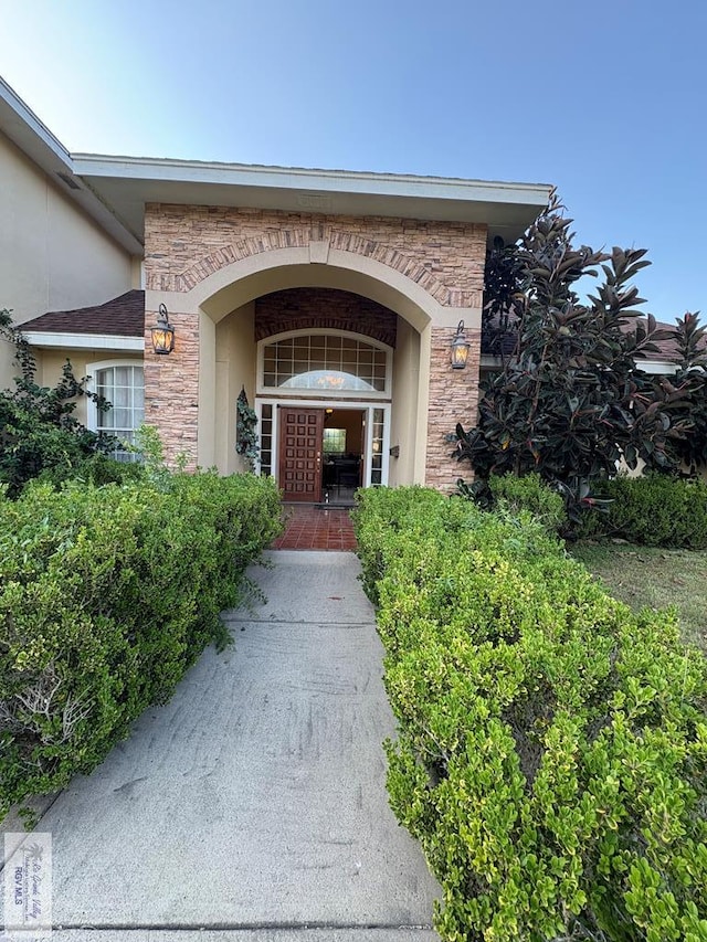 901 Plantation St, Brownsville, TX 78526 - doorway to property featuring stucco siding and stone siding