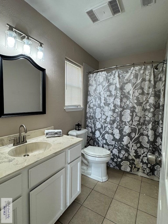 2805 Swiss Pine Ct, Harlingen, TX 78550 - bathroom with tile patterned floors, toilet, vanity, a textured wall, and curtained shower