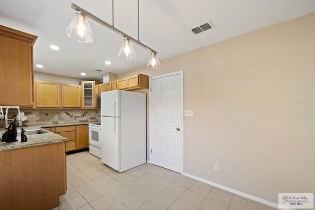 2805 Swiss Pine Ct, Harlingen, TX 78550 - kitchen featuring white appliances, backsplash, glass insert cabinets, light stone counters, and hanging light fixtures