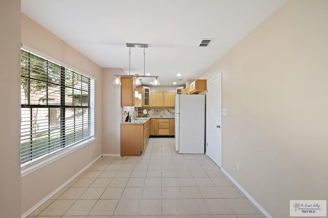 2805 Swiss Pine Ct, Harlingen, TX 78550 - kitchen with freestanding refrigerator, light countertops, glass insert cabinets, decorative backsplash, and recessed lighting