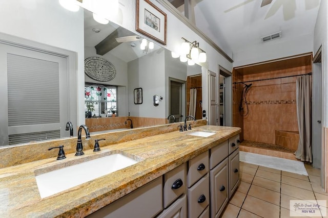 bathroom featuring vanity, lofted ceiling, tile patterned flooring, ceiling fan, and tiled shower