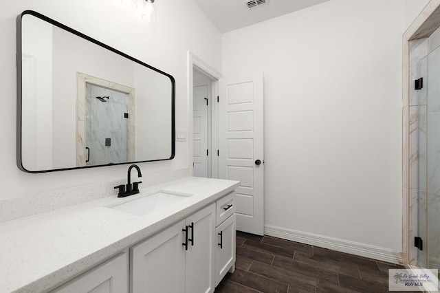 bathroom with a shower with door, vanity, and wood-type flooring