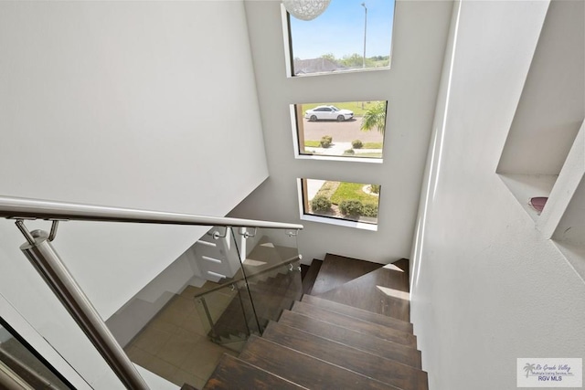 stairs with plenty of natural light and wood-type flooring