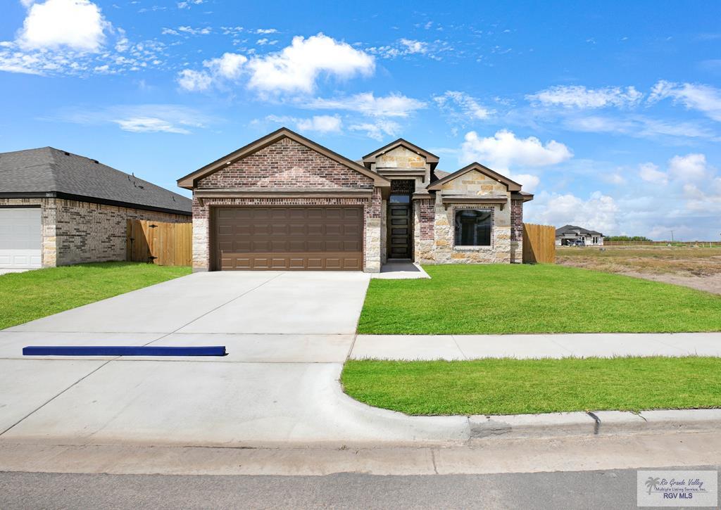 view of front of property featuring a front lawn and a garage