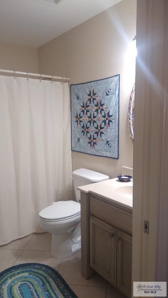 bathroom with toilet, tile patterned flooring, and vanity