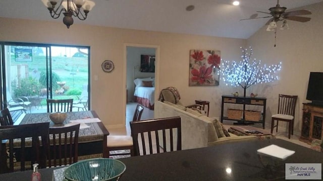 dining space featuring vaulted ceiling and ceiling fan with notable chandelier