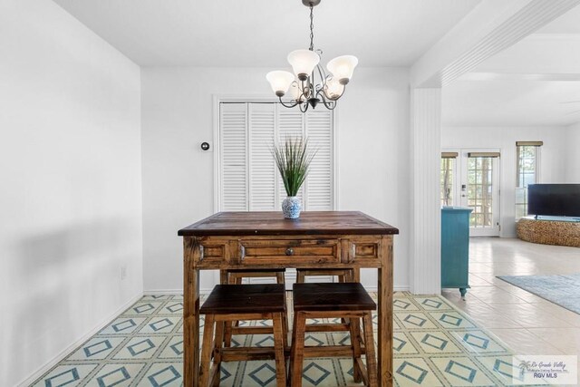 tiled dining room with a notable chandelier