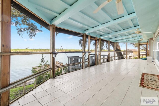 interior space with ceiling fan and a water view