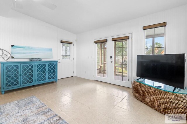 tiled living room with french doors, vaulted ceiling, and ceiling fan