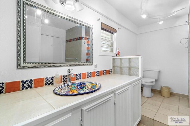 bathroom featuring tile patterned floors, vanity, and toilet