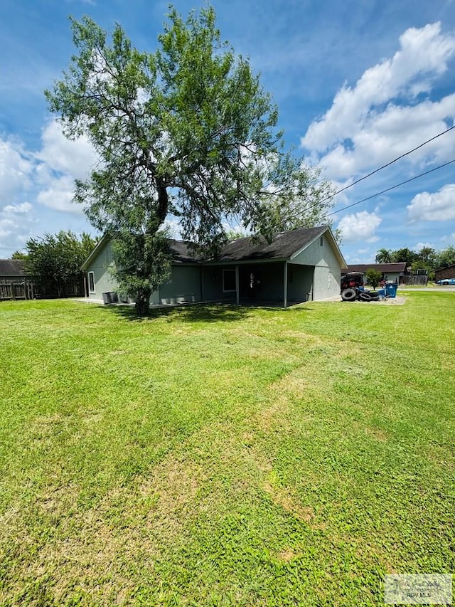 1201 Ben Lora Ln, San Benito, TX 78586 - rear view of house featuring a yard