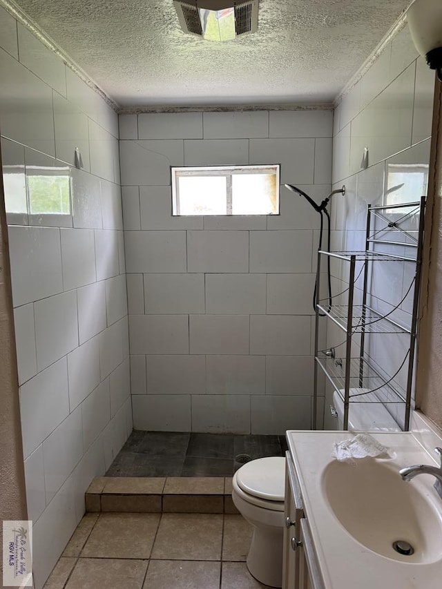 1201 Ben Lora Ln, San Benito, TX 78586 - bathroom with a textured ceiling, a tile shower, vanity, and tile patterned floors