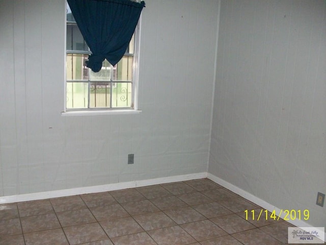 spare room featuring dark tile patterned floors