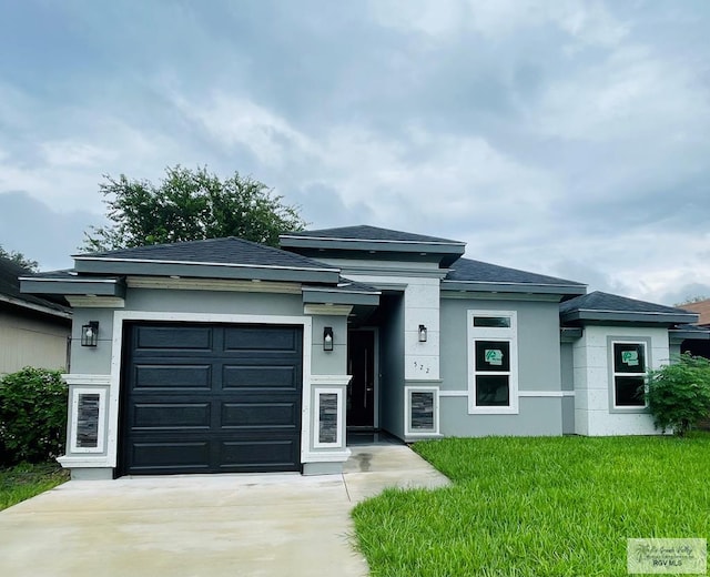 prairie-style home featuring a garage and a front yard