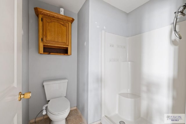 bathroom featuring toilet, tile patterned flooring, and a shower