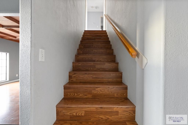 staircase featuring beamed ceiling