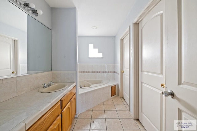 bathroom featuring tile patterned flooring, a relaxing tiled tub, and vanity