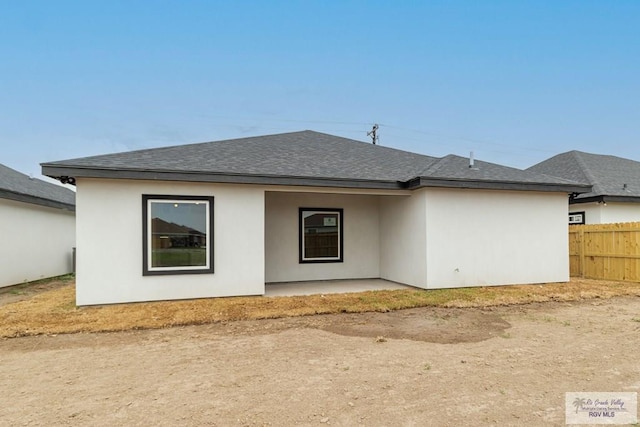 660 Tamarindo Ln Unit 2, Brownsville, TX 78521 - rear view of house featuring a shingled roof, a patio area, and stucco siding
