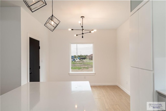 660 Tamarindo Ln Unit 2, Brownsville, TX 78521 - unfurnished dining area featuring a chandelier and light wood-style floors