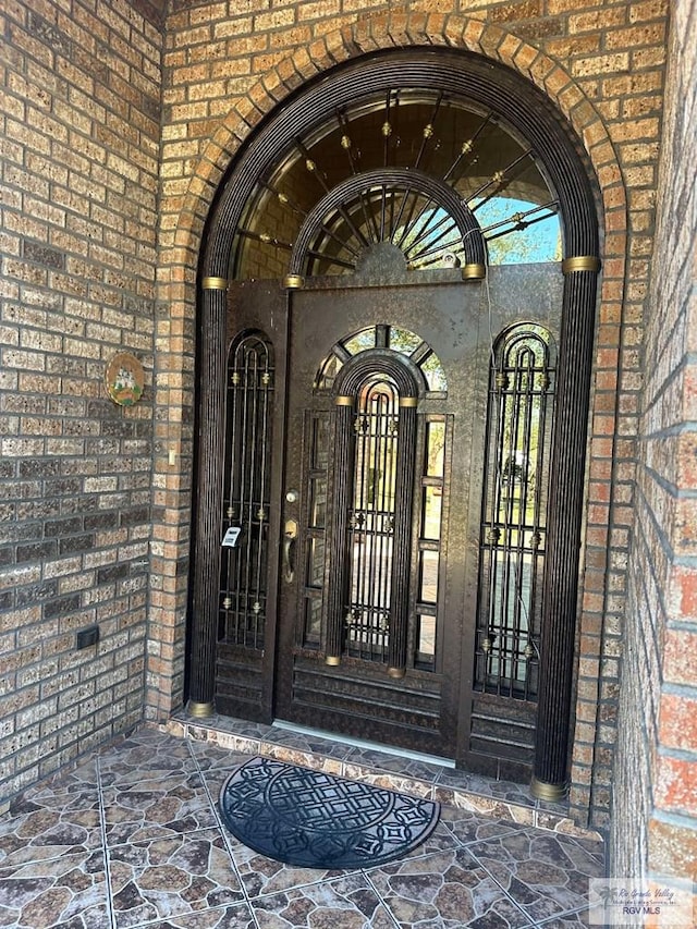 entrance to property featuring brick siding