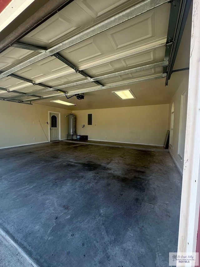 garage with a garage door opener and electric water heater