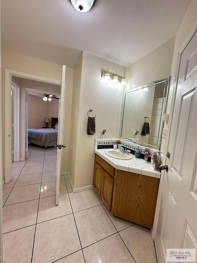 ensuite bathroom featuring ceiling fan, vanity, ensuite bath, and tile patterned floors