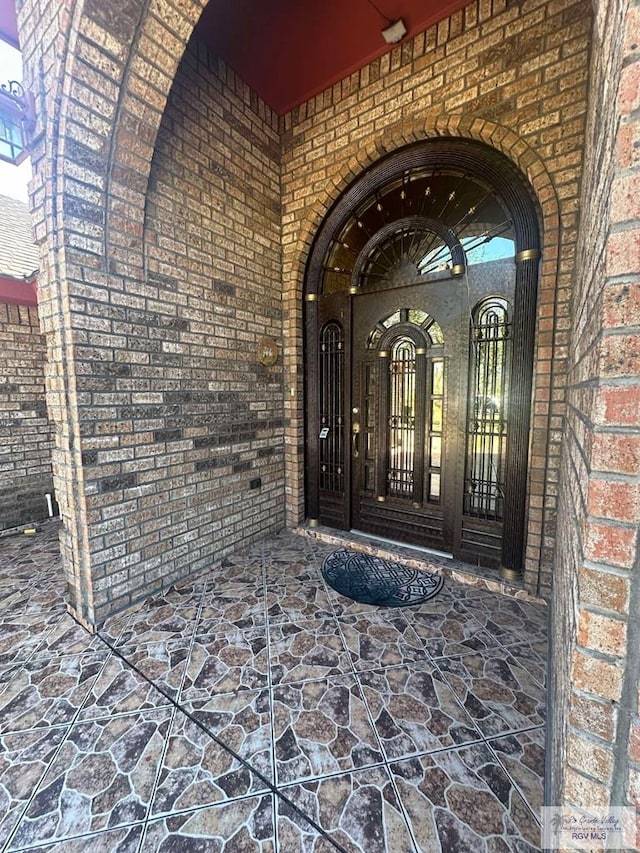 entrance to property featuring brick siding