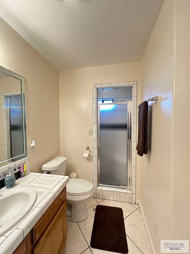 full bath with toilet, a shower stall, vanity, tile patterned flooring, and baseboards