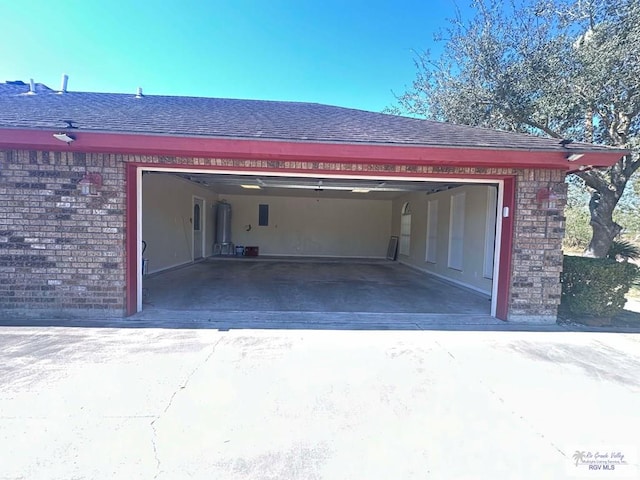 garage with driveway and water heater