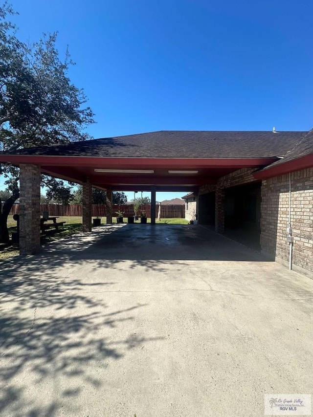 view of vehicle parking featuring driveway and fence