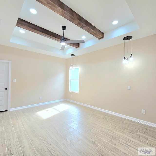 spare room featuring beam ceiling, light hardwood / wood-style flooring, a raised ceiling, and ceiling fan