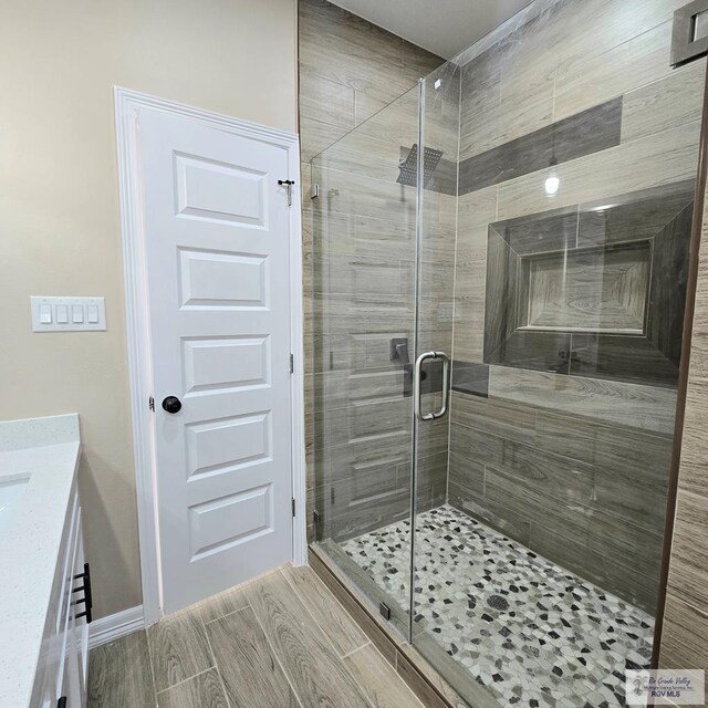 bathroom featuring vanity and a shower with door