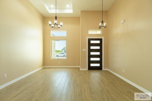 entrance foyer featuring baseboards, recessed lighting, a chandelier, and light wood-style floors
