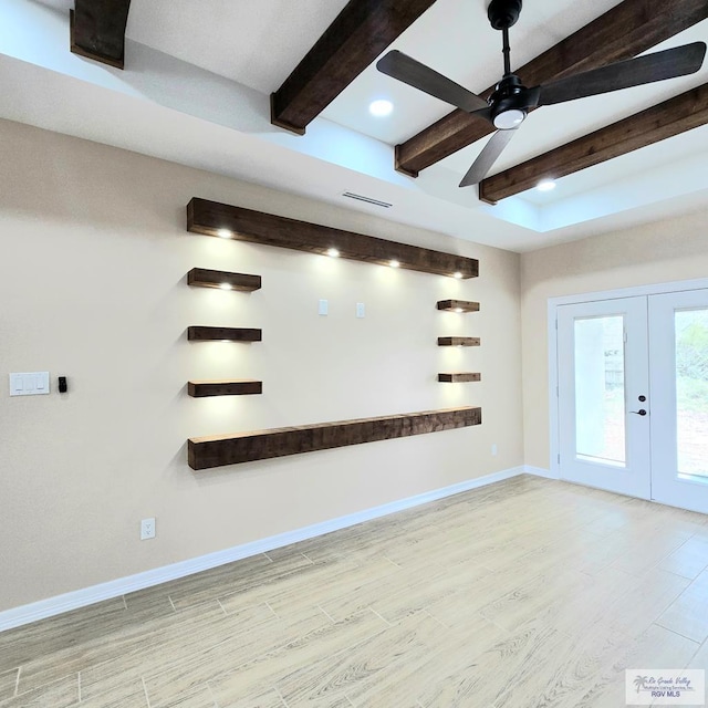 empty room featuring beam ceiling, french doors, ceiling fan, and light wood-type flooring