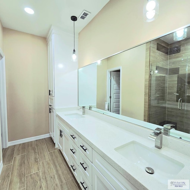 bathroom with vanity and a shower with door