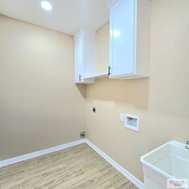 laundry area featuring sink, cabinets, washer hookup, electric dryer hookup, and light hardwood / wood-style flooring