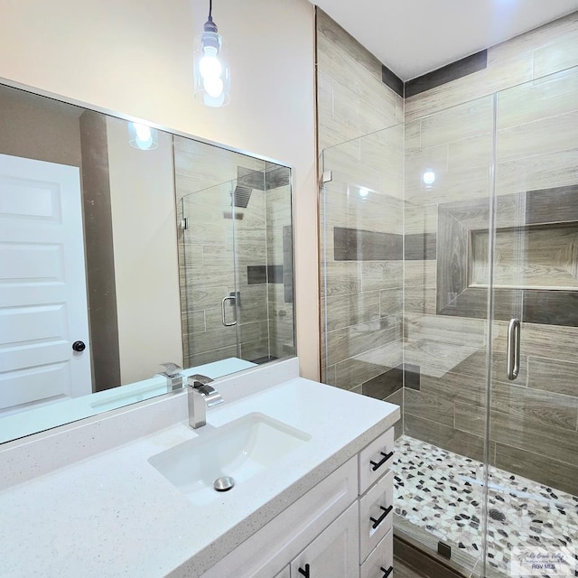 bathroom featuring vanity and a shower with door