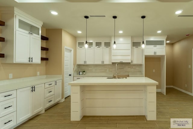 kitchen featuring white cabinetry, a sink, open shelves, and wood tiled floor